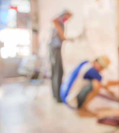 blur image of people  fixing house wall for background usage.の写真素材