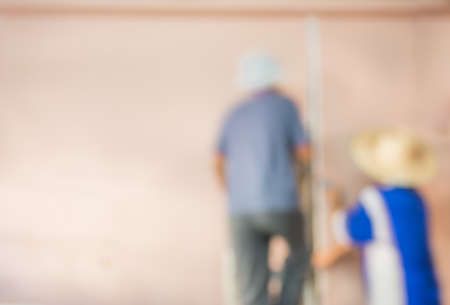 blur image of people  fixing house wall for background usage.