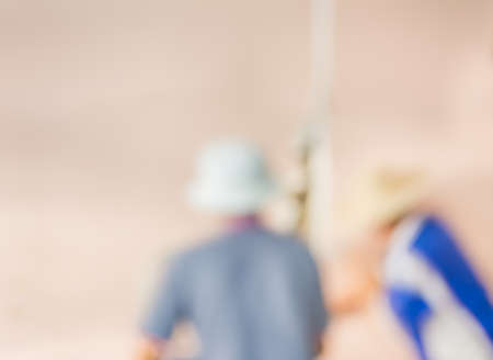 blur image of people  fixing house wall for background usage.の写真素材