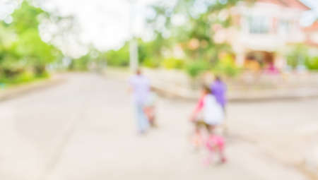 blur image of people riding bike in public park on day time for background usage.の写真素材