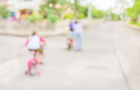 blur image of people riding bike in public park on day time for background usage.の写真素材