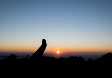 silhouette image of Thumb up means Good sign with sunset sky background.の写真素材