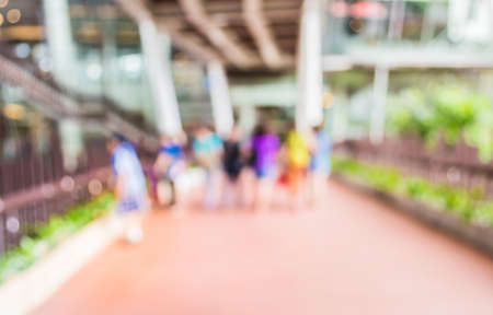 blur image of people walking at corridor with open space to the green garden for background usage.の写真素材