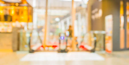 blur image of escalators at the modern shopping mall for background usage.