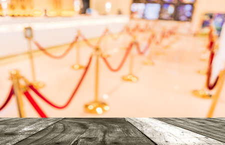 blur image of Golden fence, stanchion with red barrier rope in large mall.の写真素材