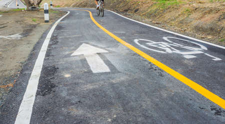 motion blur image of asphalt road and new bike lane with sign for background usage(blur on people who's rinding bike).の写真素材
