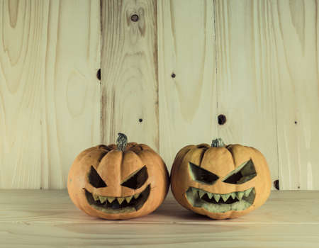 image of halloween pumpkins with a Jack 'O Lantern on wooden background.の写真素材