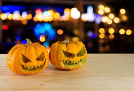 image of orange halloween pumpkin on wooden table  with bokeh in background.の写真素材