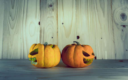 image of halloween pumpkins with a Jack 'O Lantern on wooden background.の写真素材