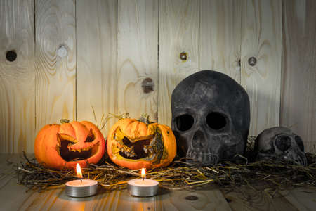 image of rotten Halloween pumpkin with candle light and dry grass. Wooden background.の写真素材