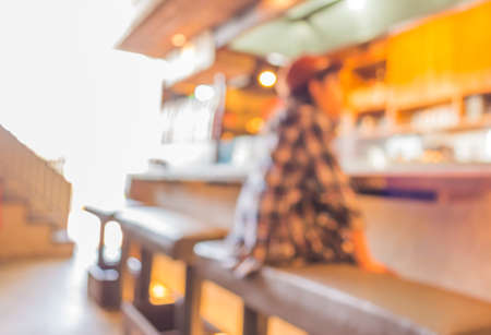 blur image of Young slim girl sits on a high bar stool in cafe .の写真素材