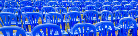 row of blue plastic chairs in the garden .の写真素材