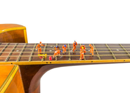 concept idea image of sound engineer doll fixing the guitar string means make thee good music as teamwork.の写真素材