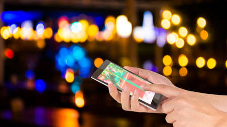 male hand is holding a modern touch screen phone and blurred bokeh background .