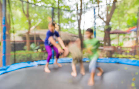 blur image of kid jumping in trampoline on day time for background usage.の写真素材