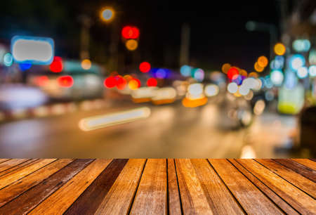 image of wood table and blur street  bokeh  with warm colorful lights in night time for background usage .の写真素材