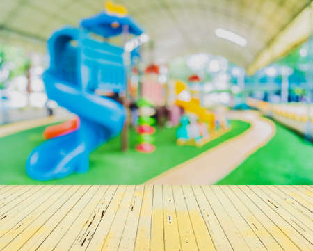 blur image of children's playground at public park for background usage.