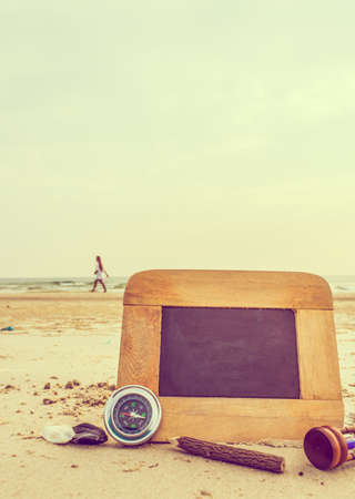 journey concept vintage tone image of chalkboard and stationery items For creative idea with blur sea in background.(selective focus on chalkboard)の写真素材