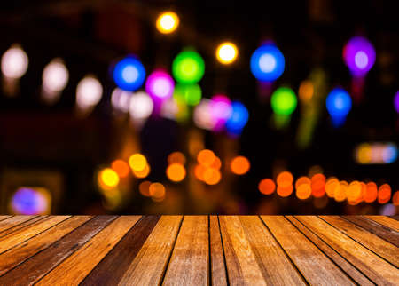 image of wood table and blurred bokeh background with colorful lights (blurred)の写真素材