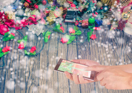 concept idea background image of hand using phone with ornaments in Christmas time .の写真素材