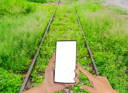 image of male hand is holding a modern touch screen phone and Railway lines