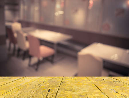 Abstract blur image of empty restaurant with wood table and chairs for background usage.(vintage...