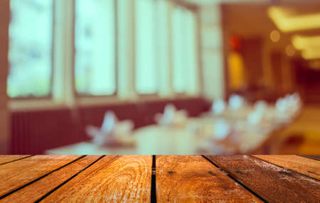 Abstract blur image of empty restaurant with wood table and chairs for background usage.(vintage...