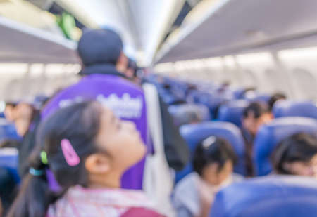 blur image of inside the airplane with people for background usage.の写真素材