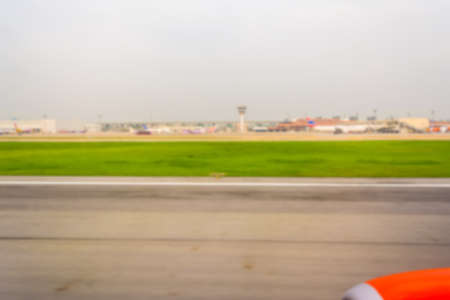 blur image of inside airplane to see runway and airport for background usage.の写真素材