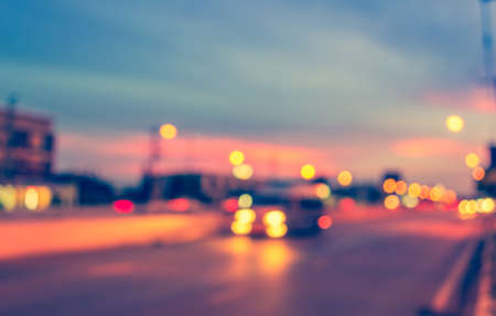 image of blur car on road in evening for background usage. (vintage tone)