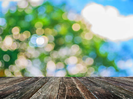 wood table and blur image of Abstract Bokeh of tree green color background .の写真素材