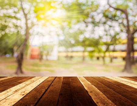 wood table and Abstract blur image of green tree bokeh for background usage.の写真素材