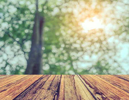 wood table and Abstract blur image of green tree bokeh for background usage .の写真素材