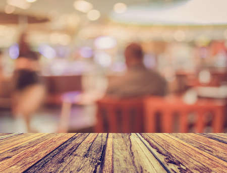 vintage tone image of wood table and Coffee shop blur background with bokeh .の写真素材