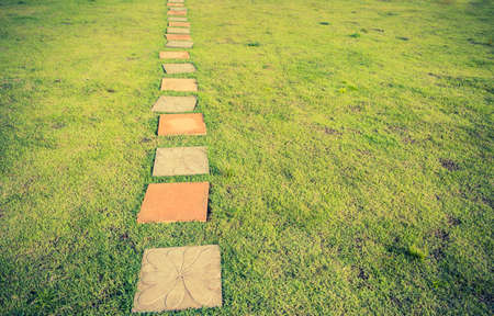 vintage tone image of grass field on both side and pathway.の写真素材