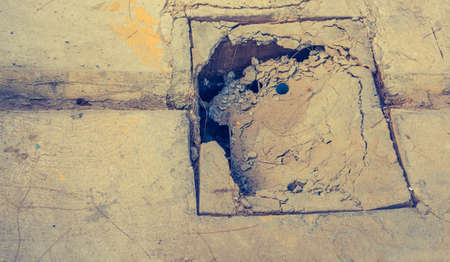 vintage tone of broken cement manhole lid on day time for background.の写真素材