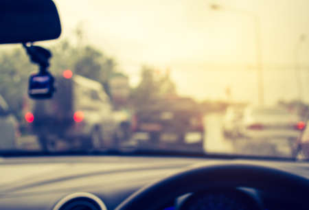vintage tone blur image of people driving car on day time for background usage.(take photo from...