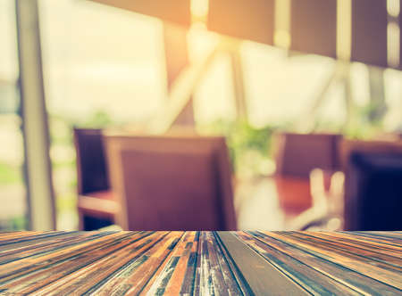 Abstract blur image of empty restaurant with wood table and chairs for background usage.(vintage...