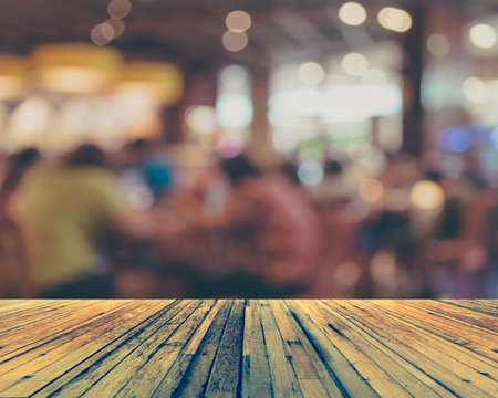 vintage tone image of wood table and Coffee shop blur background with bokeh .