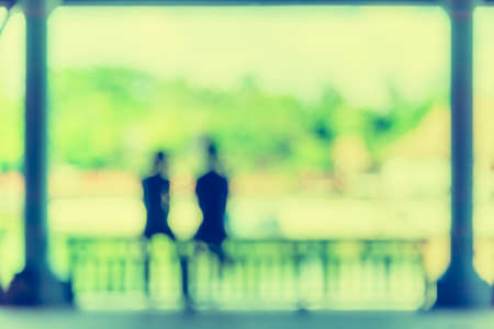 vintage tone blur image of two people sit near the lake .の写真素材
