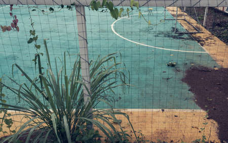 vintage tone image of old soccer goal in field.