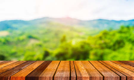 wood table and blur image of green mountain.の写真素材
