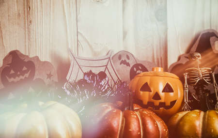 vintage tone image of Halloween pumpkin and a variety of ornaments on a wood table with Wooden background .の写真素材