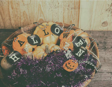 vintage tone image of Halloween pumpkin and a variety of ornaments on a wood table with Wooden background .の写真素材