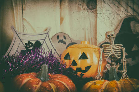 vintage tone image of Halloween pumpkin and a variety of ornaments on a wood table with Wooden background .の写真素材