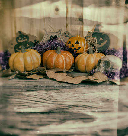 vintage tone image of Halloween pumpkin and a variety of ornaments on a wood table with Wooden background .の写真素材