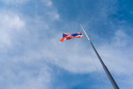Flag of Thailand with blue sky for background.