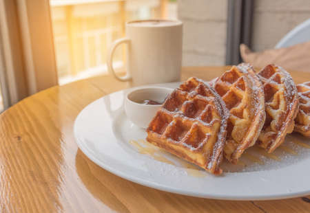 Stack of waffles on wood table near the window on wood table.の写真素材
