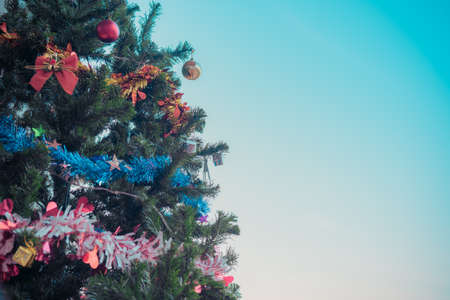 vintage tone image of Christmas tree and ornament with clear blue sky in background on day time.の写真素材