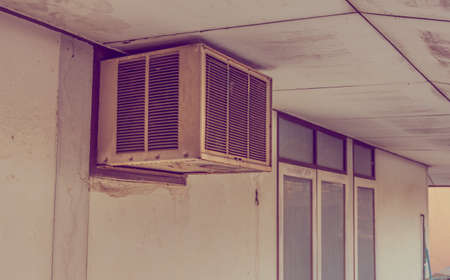 image of old air compressor hanging on the wall on day time .の写真素材
